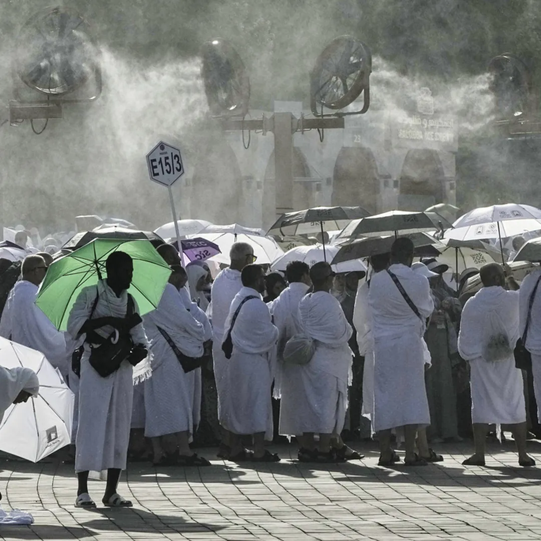 Hajj pilgrims using umbrellas and cooling mist during hot weather