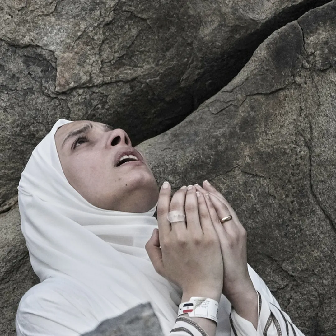 Woman praying on Mount Arafat during Hajj pilgrimage